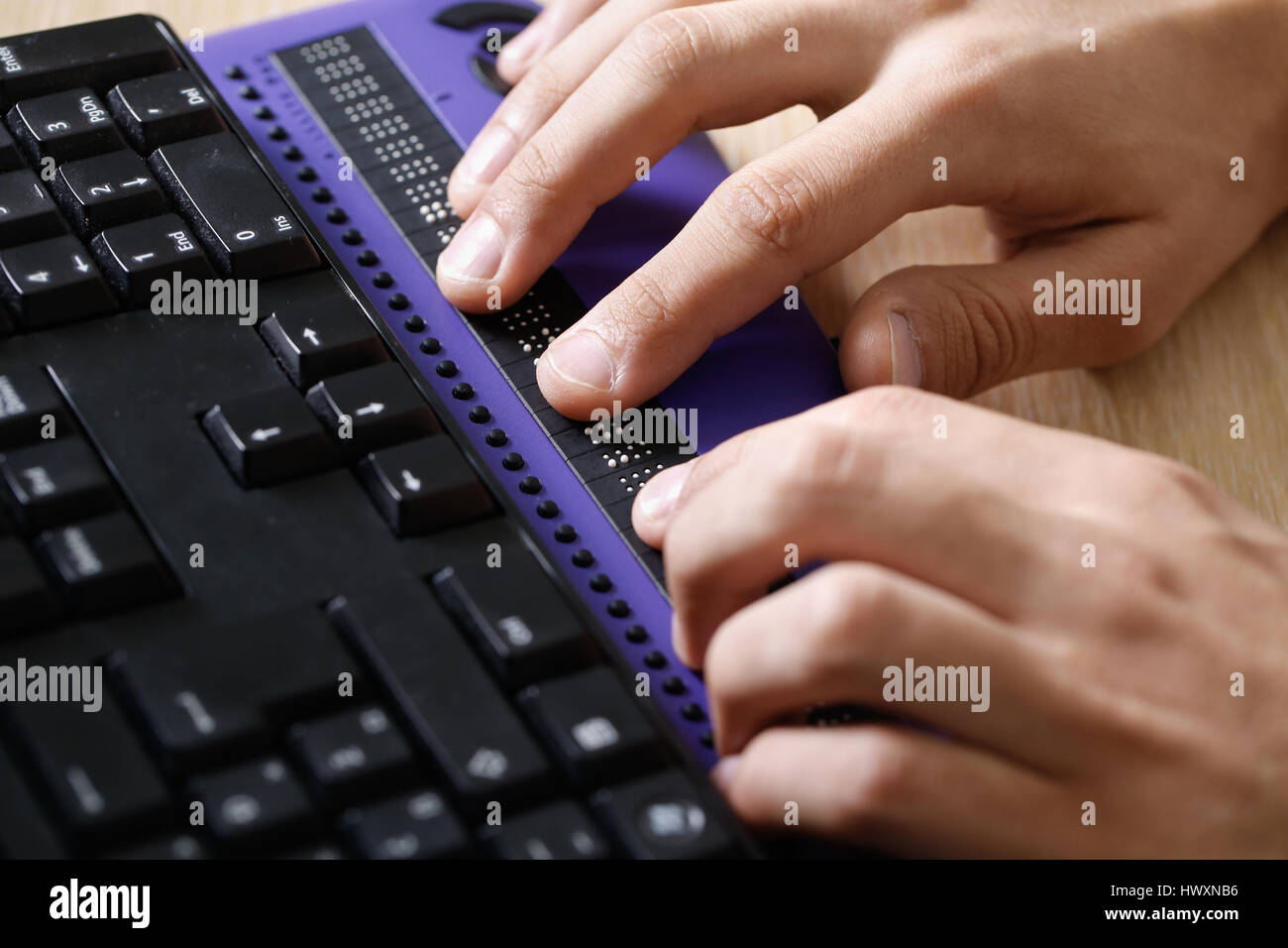 Blind person using computer with braille computer display and a