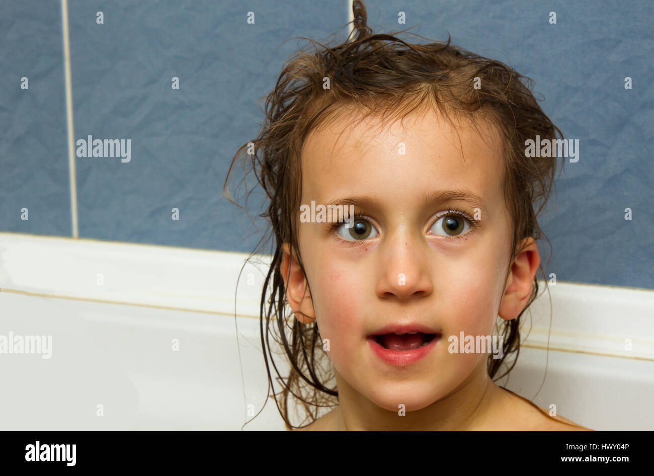 Cute little girl washes her hair. Clean kid after shower. Children