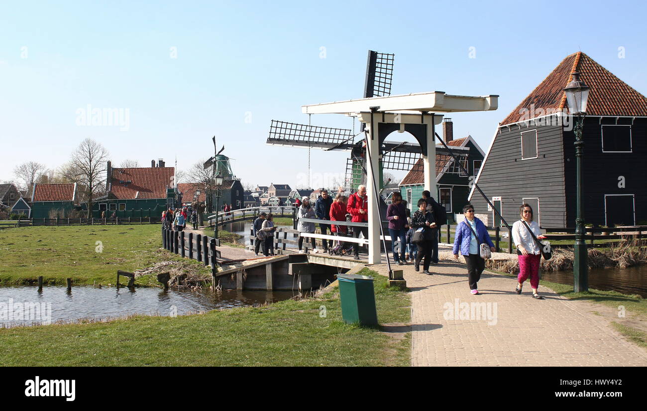 Tourists crossing a wooden draw bridge at the open-air museum of  Zaanse Schans, Zaandam, Netherlands Stock Photo