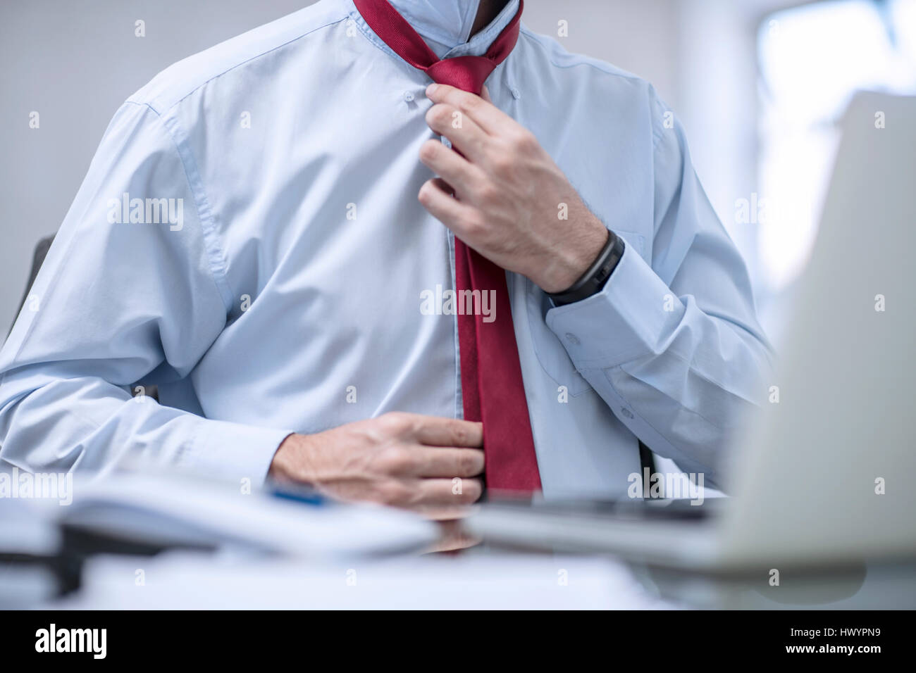 Person in office fixing his red tie Stock Photo