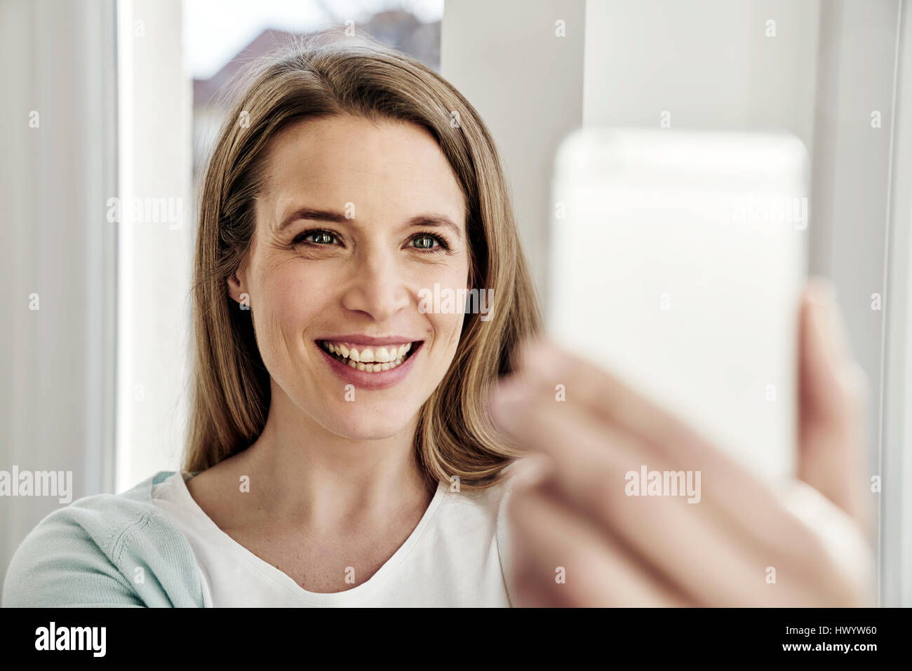 Happy woman taking a selfie Stock Photo - Alamy