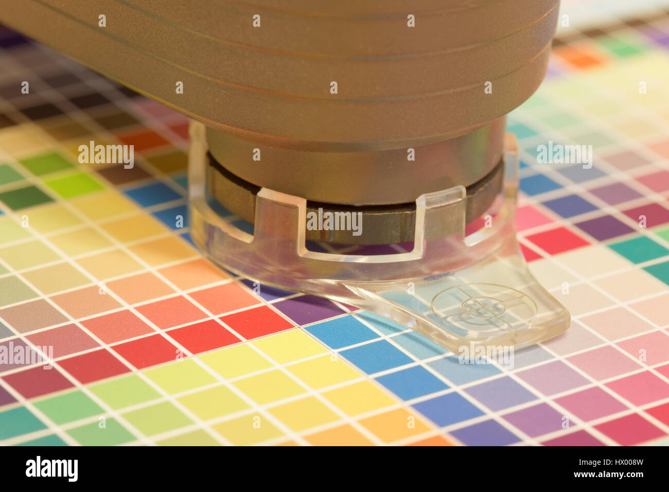 Closeup of spectrometer used for proofing on a leaf of the multi color test print in a pre-press workshop Stock Photo