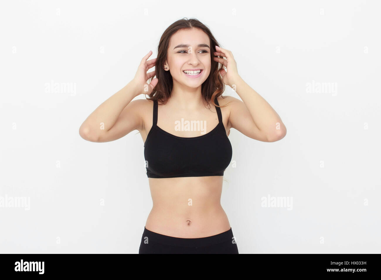 Beautiful girl in black top on white background shows emotion Stock Photo