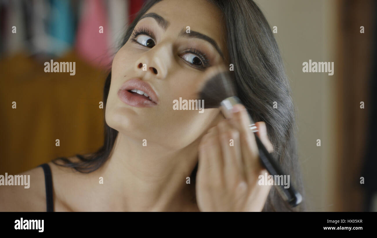 Low angle view of woman applying blush makeup in mirror Stock Photo