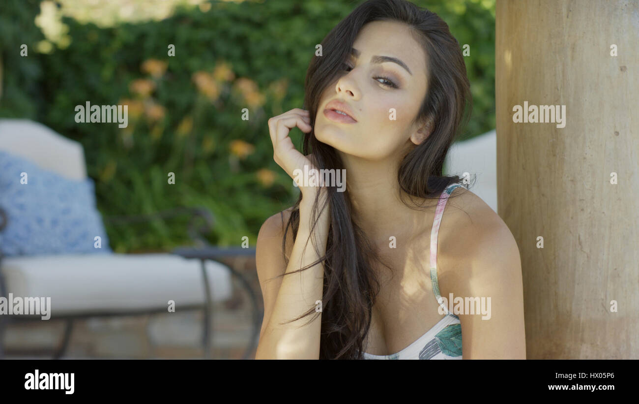 Portrait of sultry woman with long hair wearing swimsuit Stock Photo