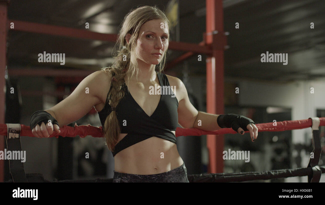 Portrait of serious female boxer standing in boxing ring Stock Photo