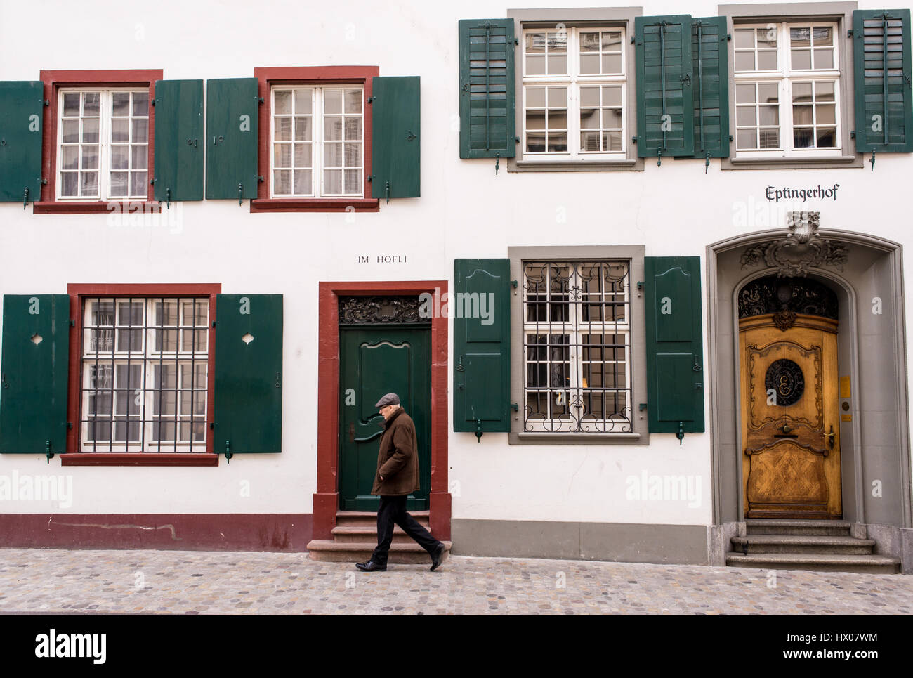 Old man walking in front of traditional medieval house in Basel old town, Altstadt Grossbasel,Switzerland. Stock Photo