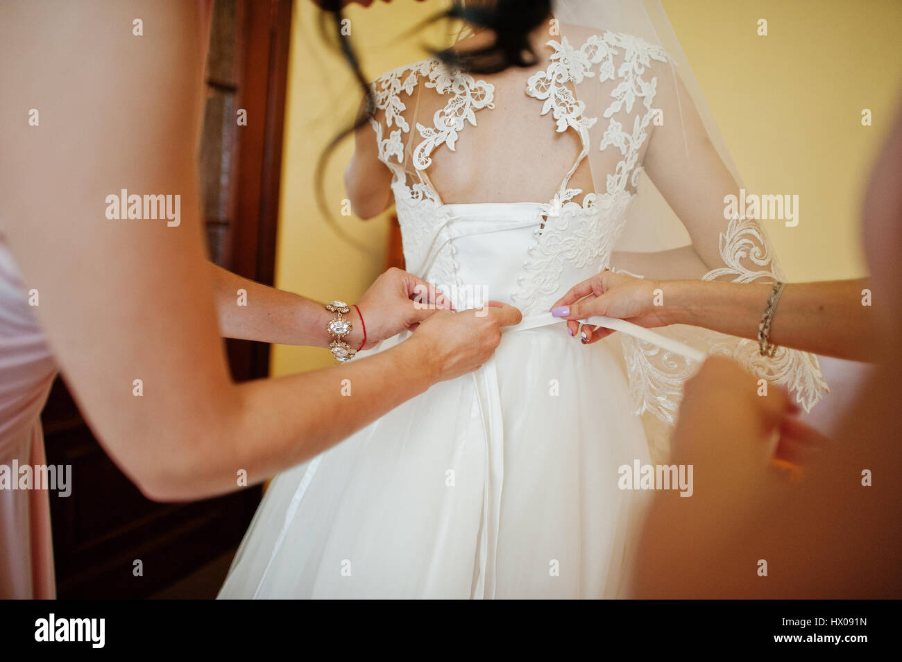 Fashionable Bridesmaids On Pink Dresses Helped Wear Bow On Back Of