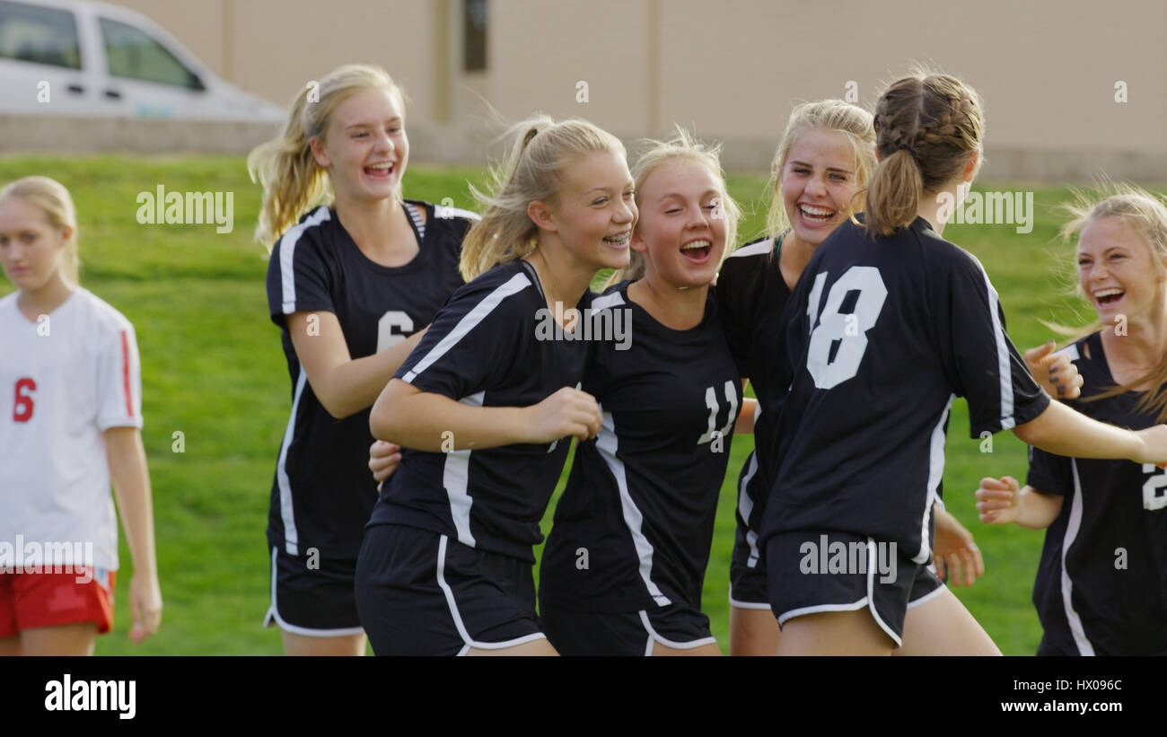 Proud athlete with soccer teammates cheering after game victory on field Stock Photo