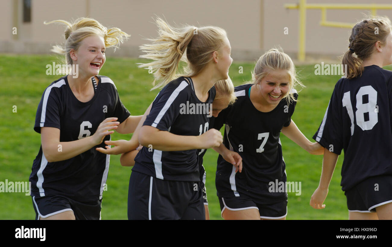 Proud athlete with soccer teammates cheering after game victory on field Stock Photo