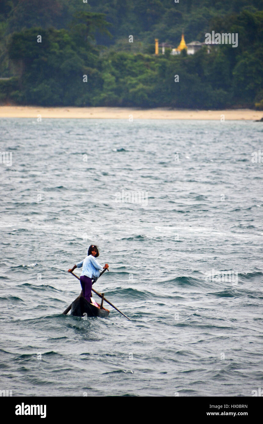 A young girl rows a traditional boat to the village of Makyone Galet, Lampi National Marine Park, Myeik Archipelago, Myanmar Stock Photo