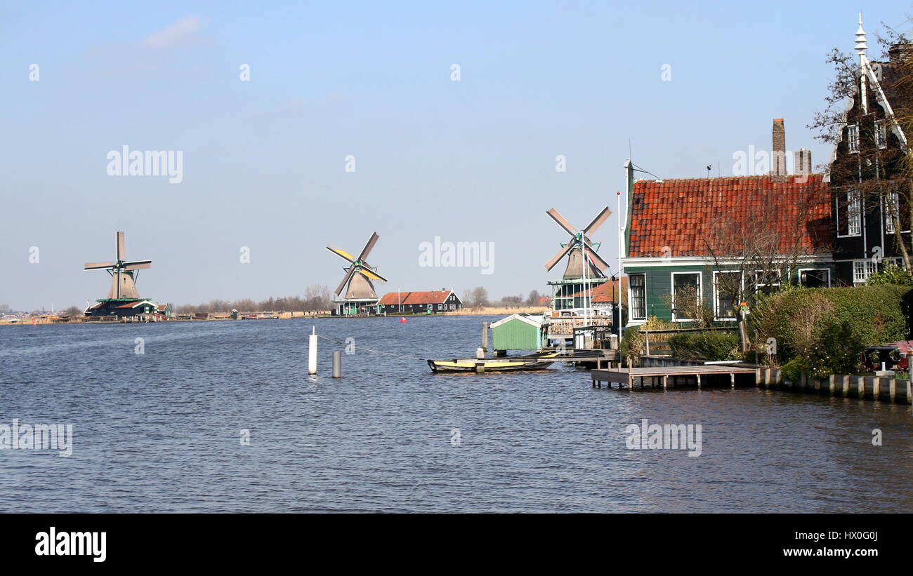 Traditional Dutch wooden houses & windmills at village of Zaanse Schans, Zaandam, Netherlands. Mills right to left De Kat, De Zoeker, Het Jonge Schaap Stock Photo