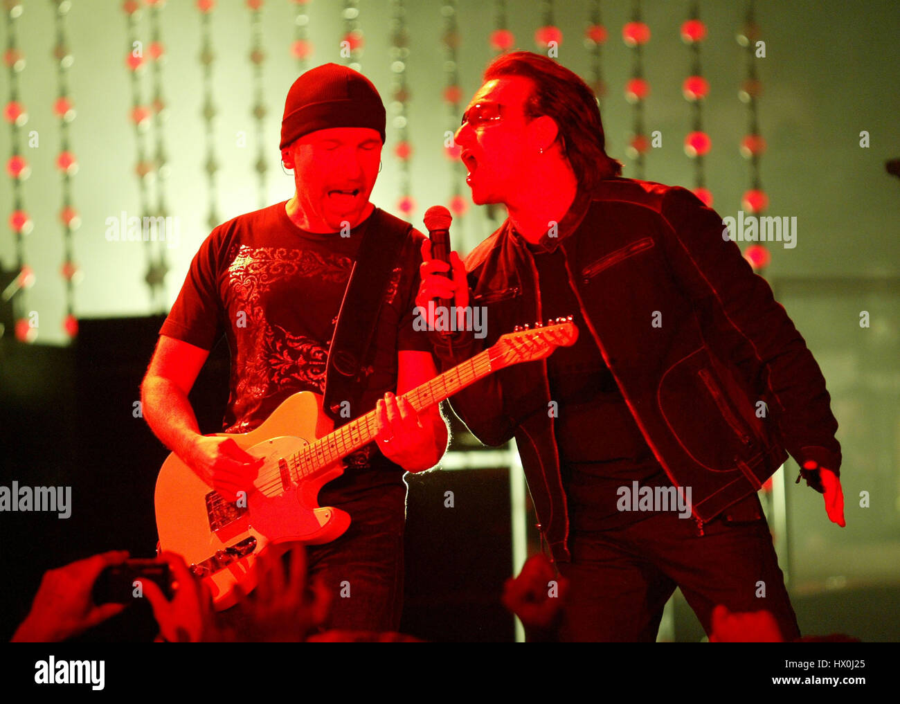 Lead singer of U2, Bono, with The Edge, in concert in San Diego, CA on