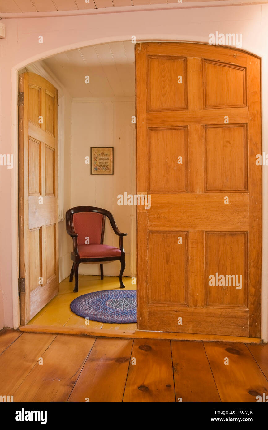 Red upholstered antique wooden high back armchair in a room at the 1790