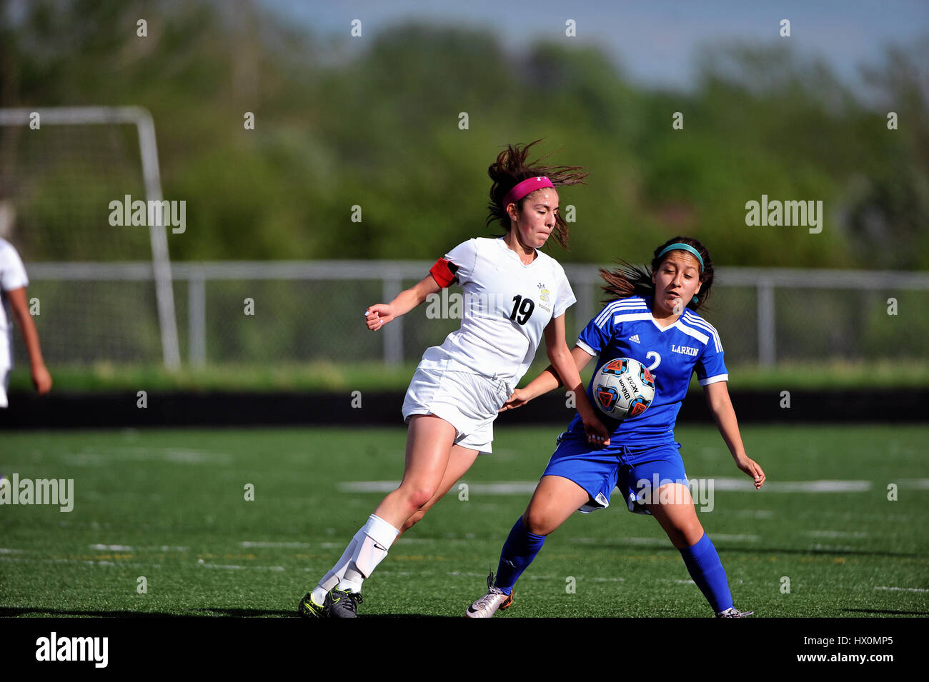 Opposing players in pursuit of a loose ball.during a high school soccer match, USA. Stock Photo