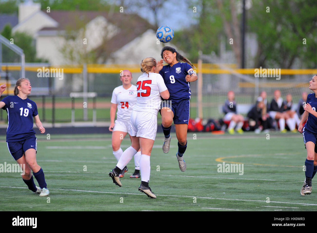Player executing a header over a defender during a high school match. USA. Stock Photo