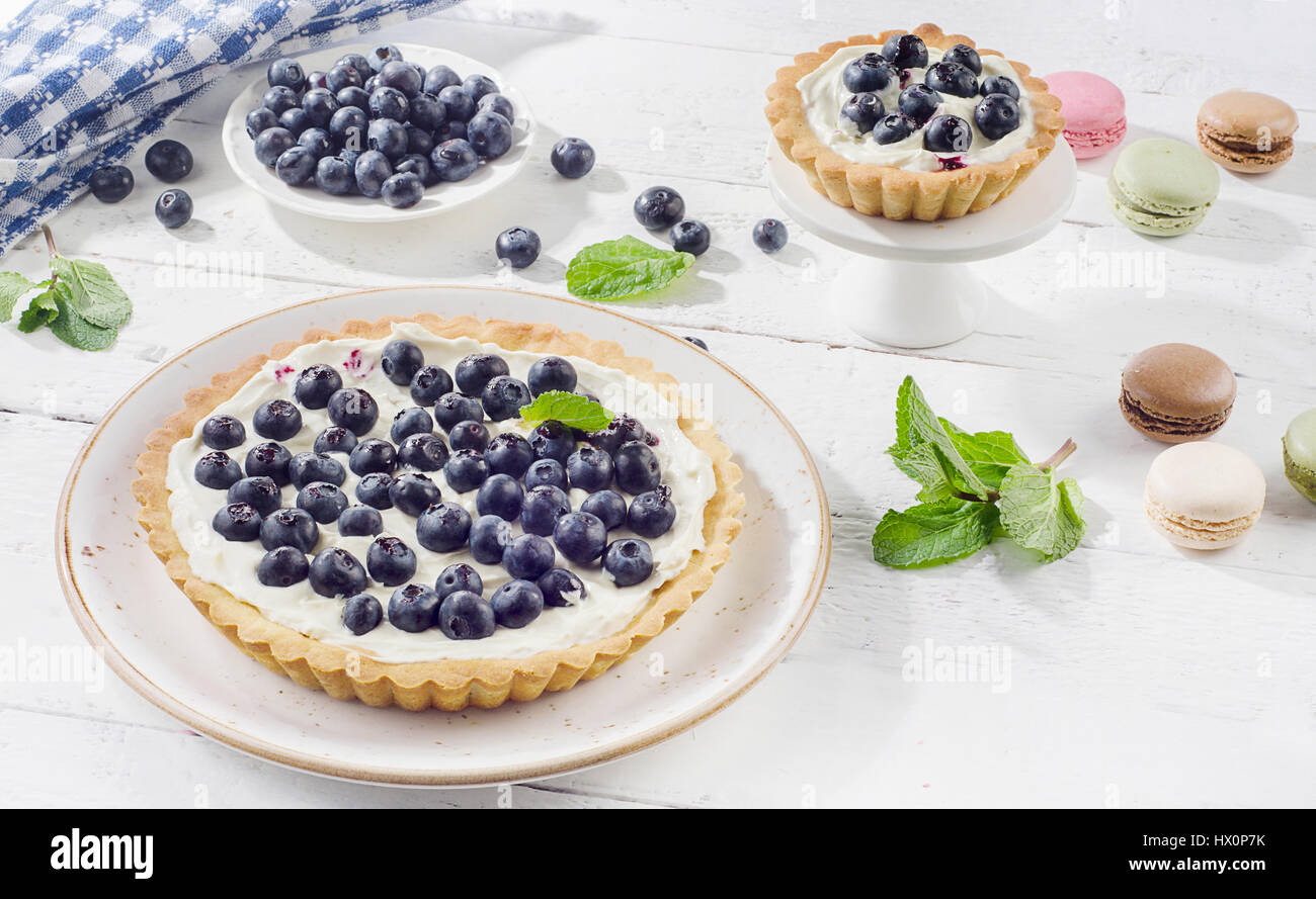 Cakes with blueberries and whipped cream and macaroons Stock Photo - Alamy