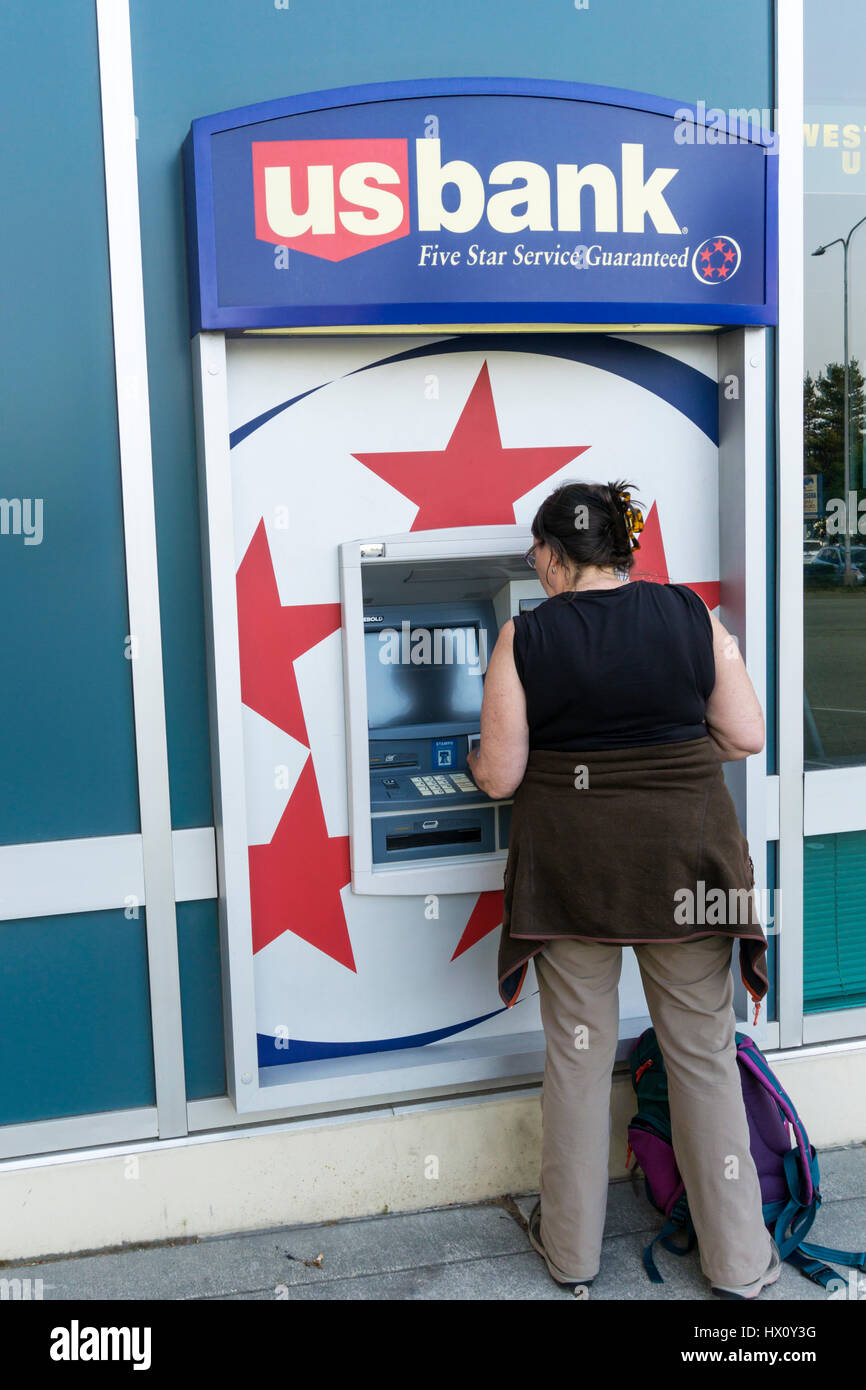 Woman using USbank cash machine in West Seattle. Stock Photo