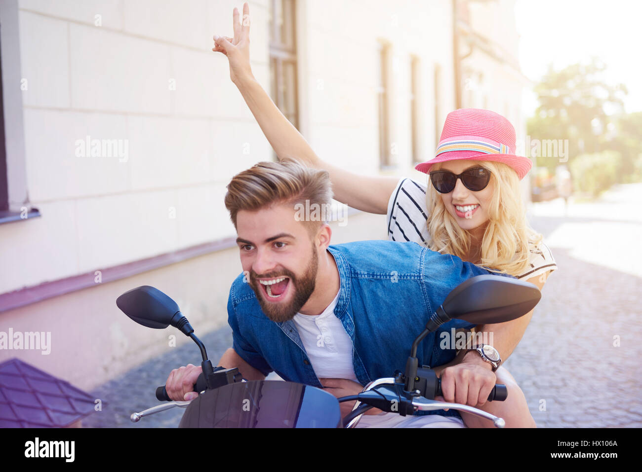 Couple driving a scooter at the city Stock Photo - Alamy