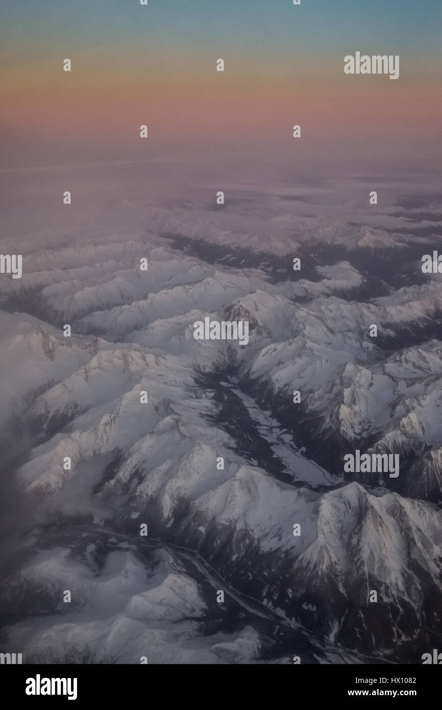 Aerial view of snowy mountains at sunset Stock Photo - Alamy