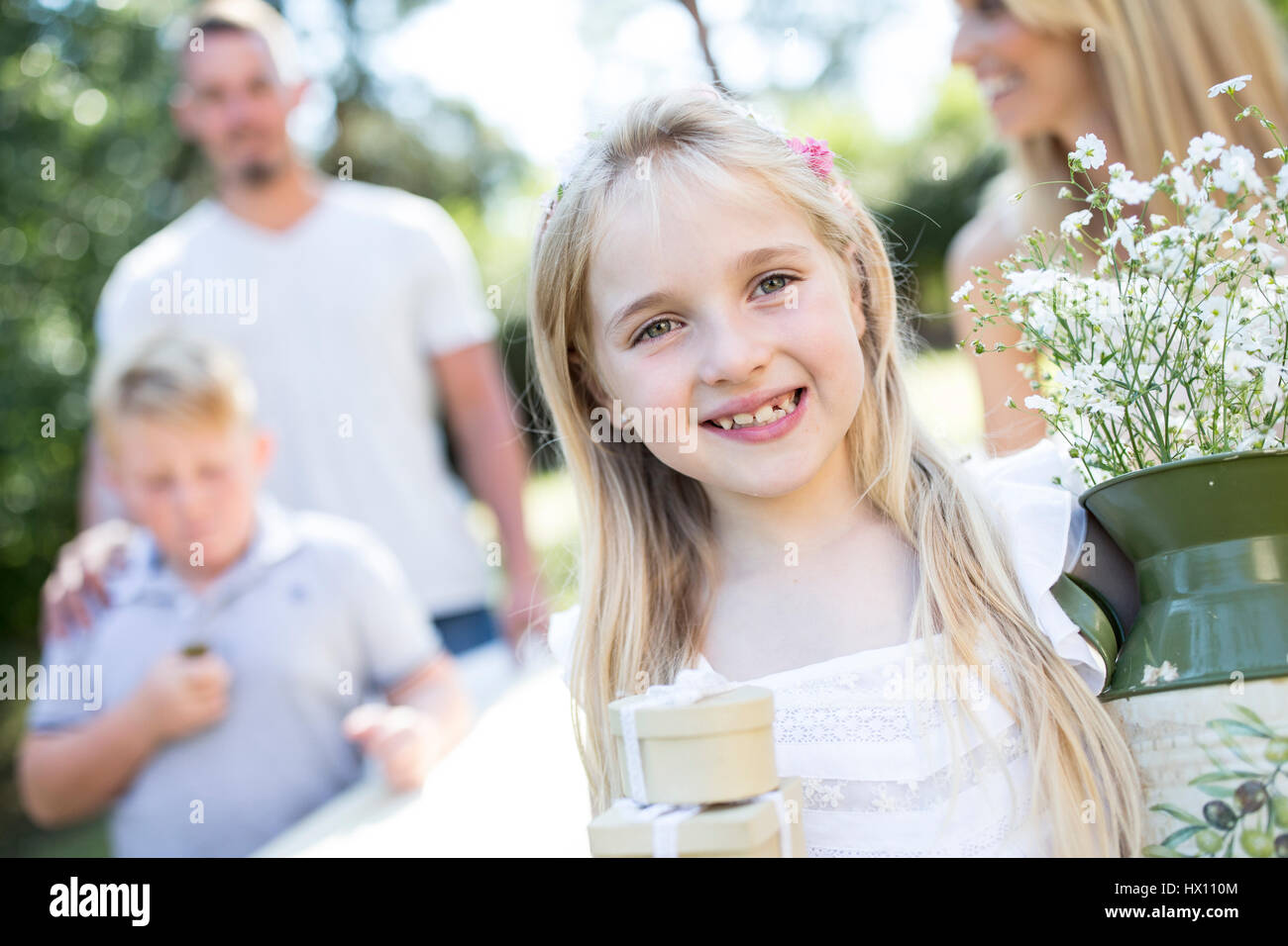 Portrait of smiling girl outdoors with family in background Stock Photo ...