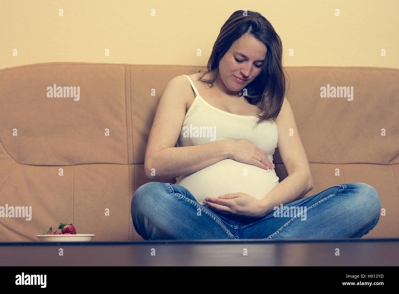 Intimate portrait of young pregnant woman holding her belly Stock Photo ...