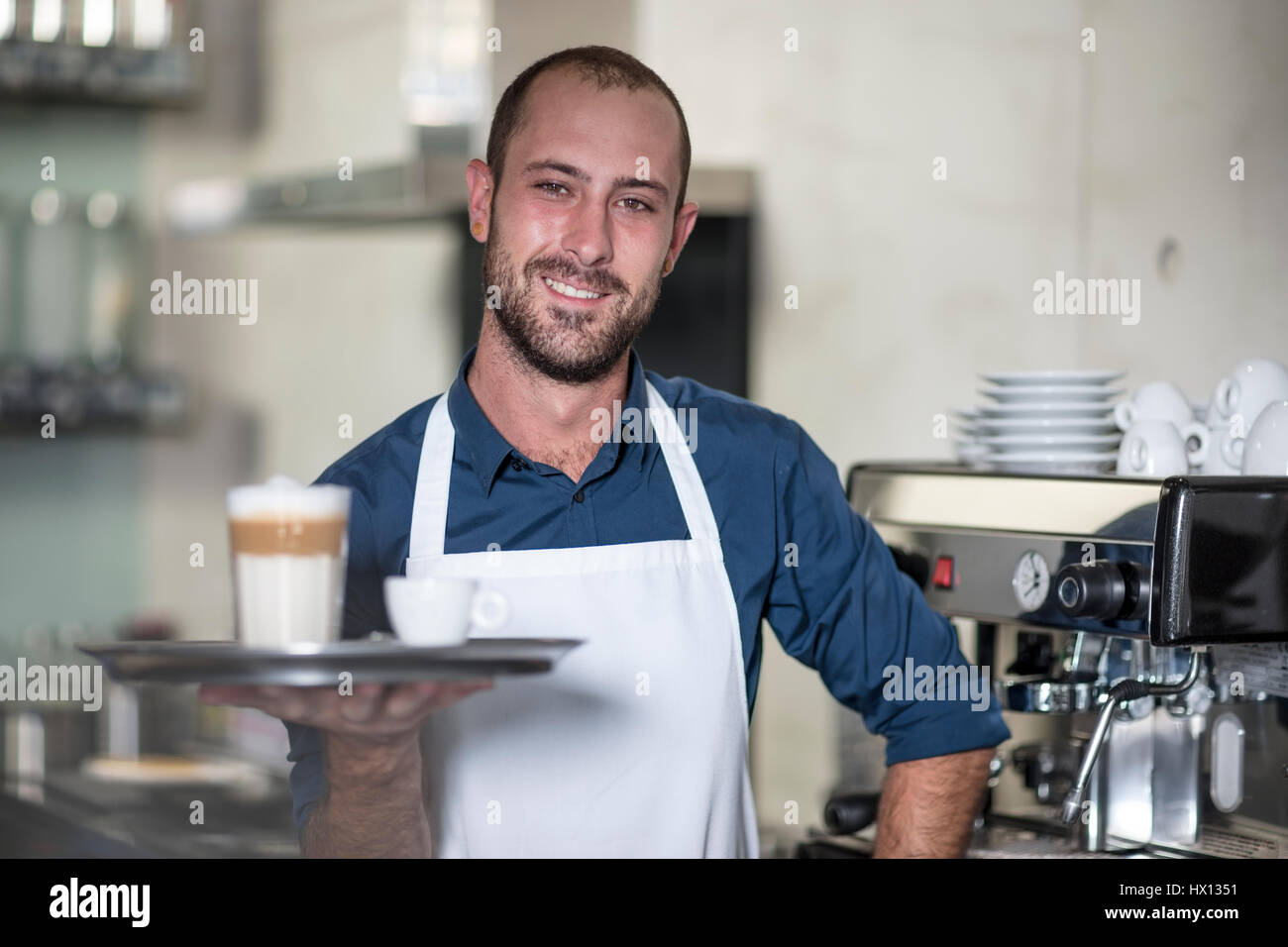 Portrait of smiling barista serving Latte Macchiato Stock Photo