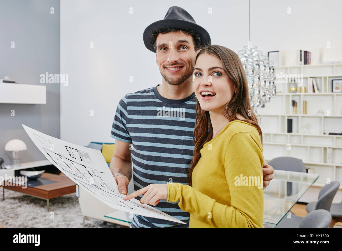 Couple With Floor Plan Choosing Furniture In Furniture Shop Stock