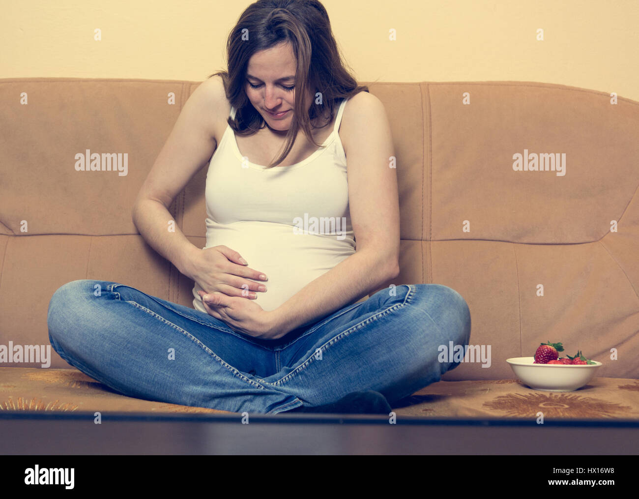 Intimate portrait of young pregnant woman holding her belly Stock Photo ...