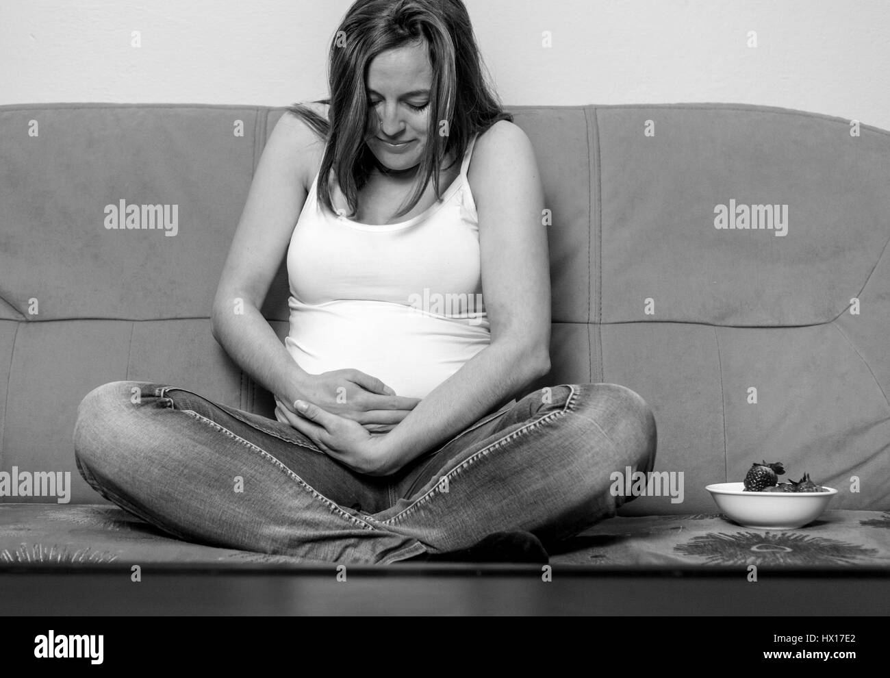 Intimate portrait of young pregnant woman holding her belly Stock Photo ...