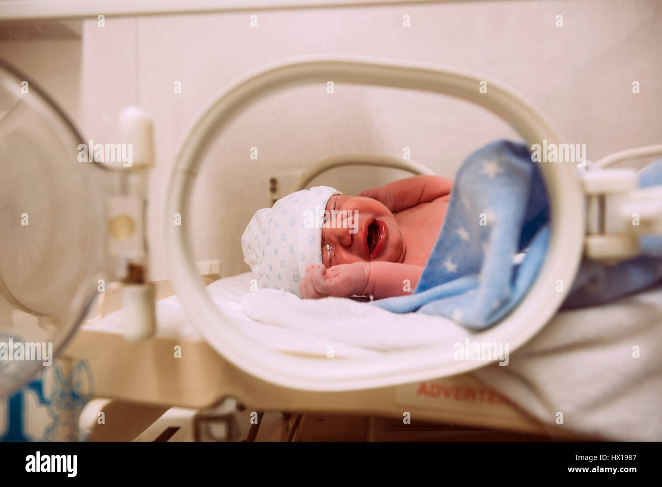 Crying newborn baby in an incubator Stock Photo