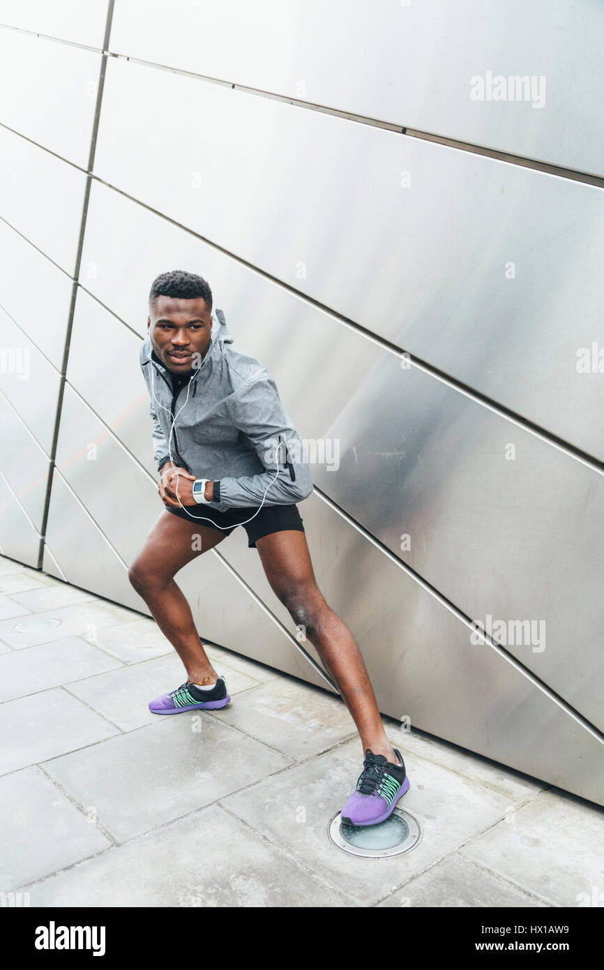 Athlete stretching at building front Stock Photo