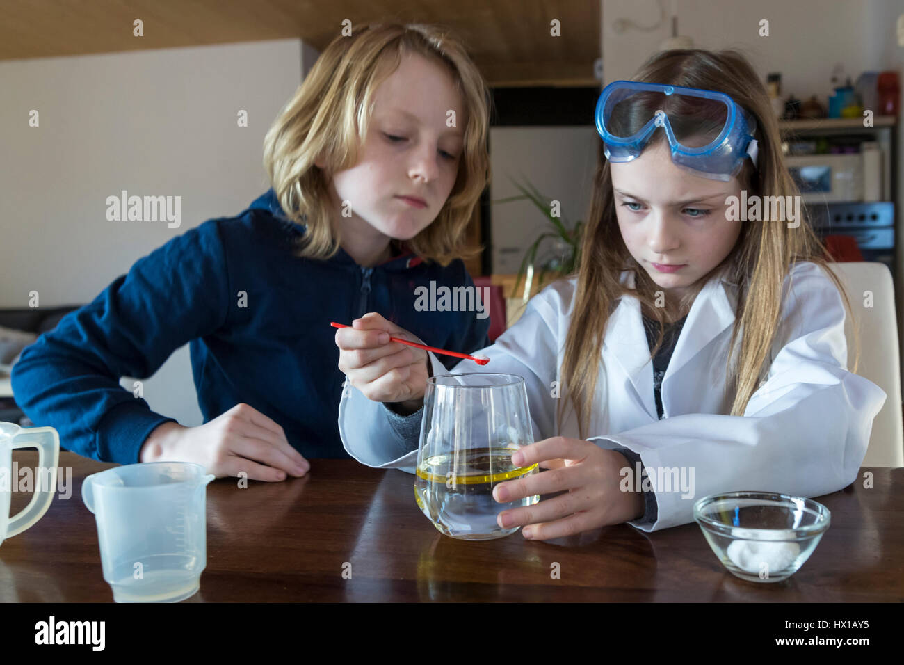 Two children using chemistry set at home Stock Photo