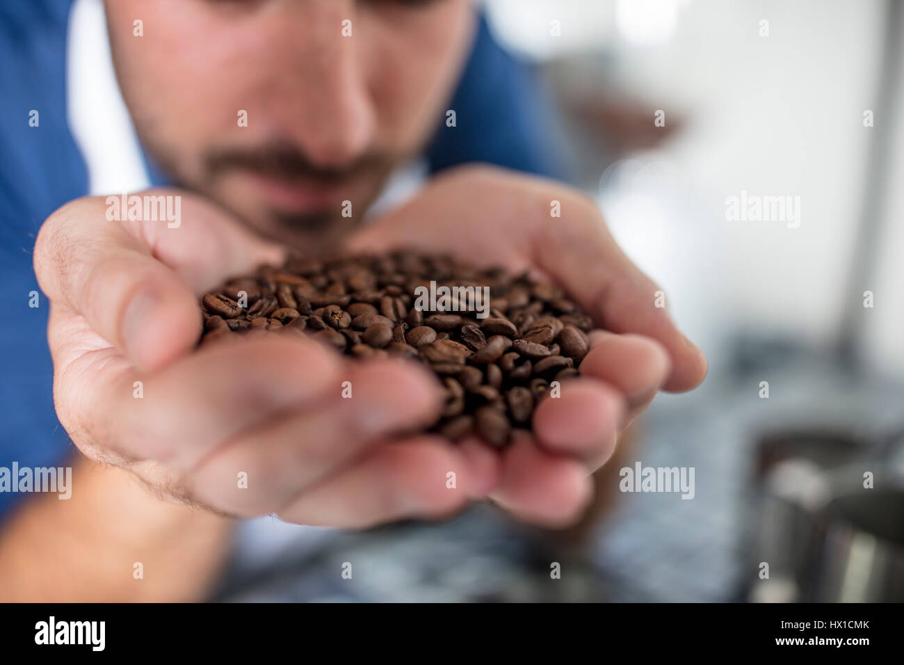 Man smelling handful of coffee beans Stock Photo