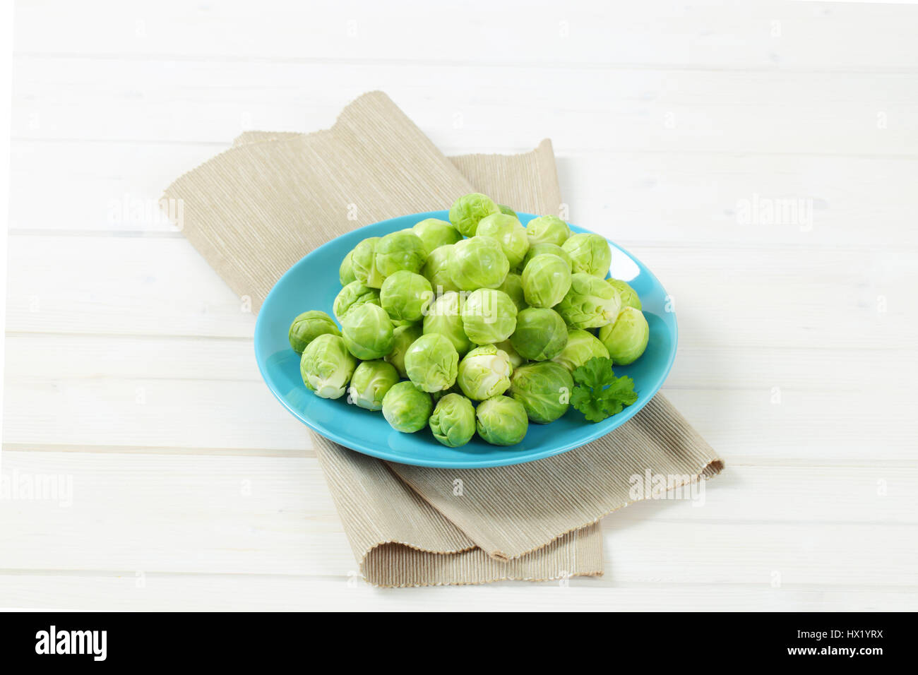 plate of raw Brussels sprouts on beige place mat Stock Photo