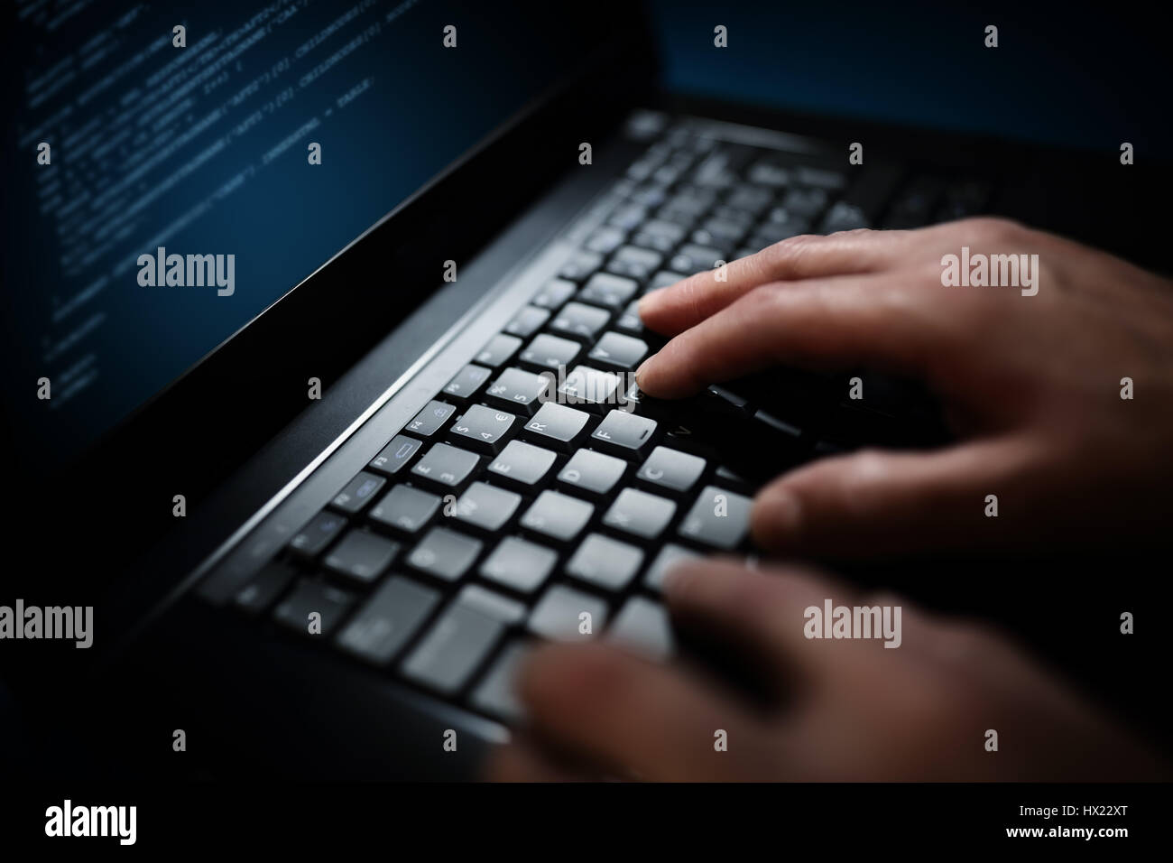 Programmer or computer hacker typing code on laptop keyboard Stock Photo