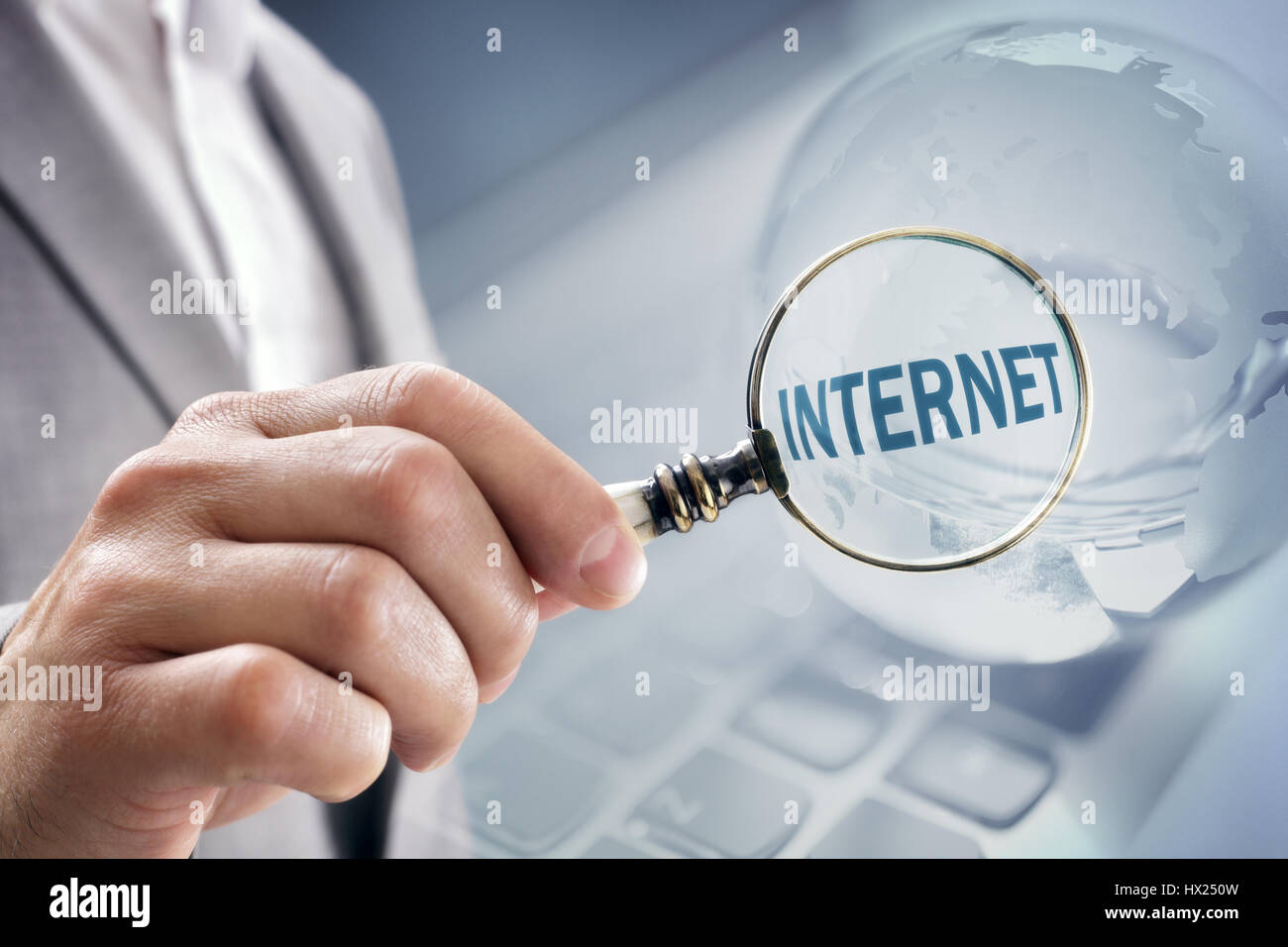 Businessman with magnifying glass searching the Internet Stock Photo