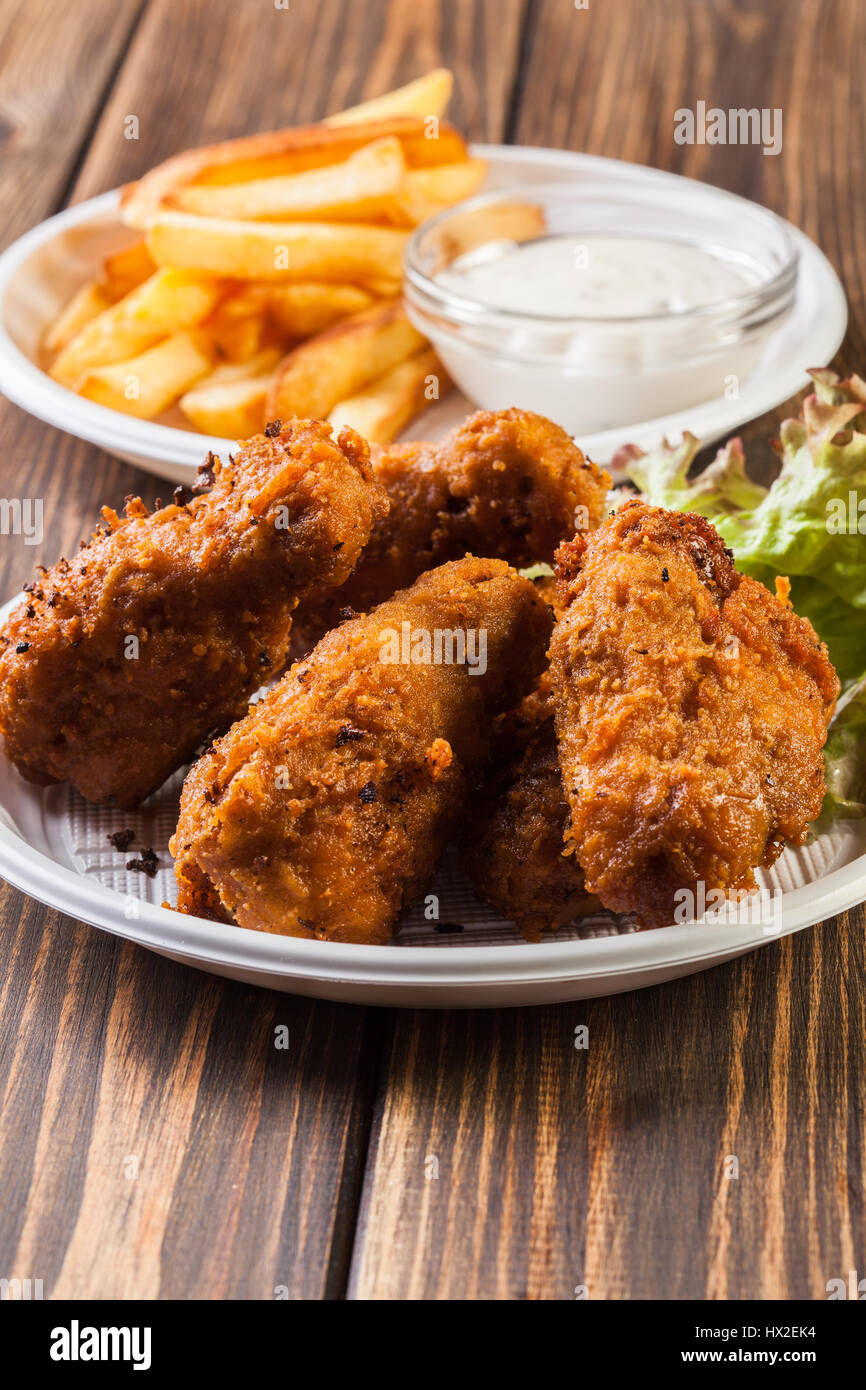 Crisp crunchy golden chicken wings with chips Stock Photo