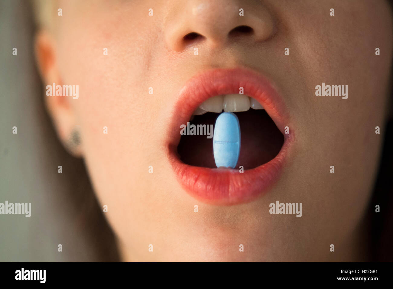 Vitamins And Pills.  Taking Medicine, Holding Pill between teeth.  Open Mouth. Supplements, Health Concept. Stock Photo