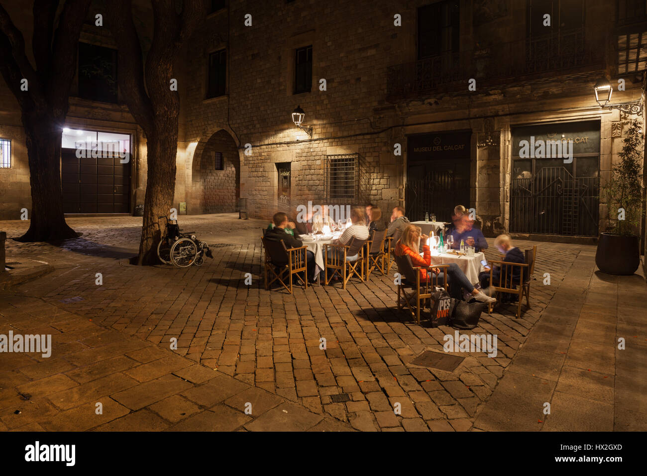 People having supper with wine at outdoor cafe restaurant on Placa Sant Felip Neri square at night in Gothic Quarter of Barcelona, Catalonia, Spain, E Stock Photo