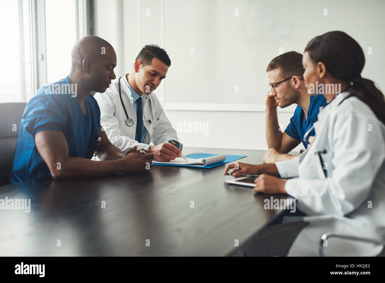Multiracial medical team having a meeting with doctors in white lab