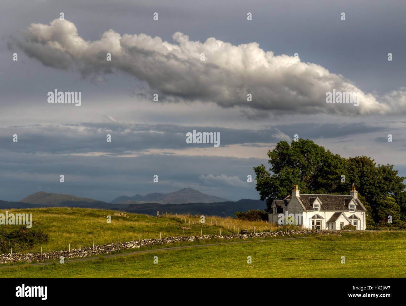 Scottish cottage with scottish fence and big cloud above, Isle of