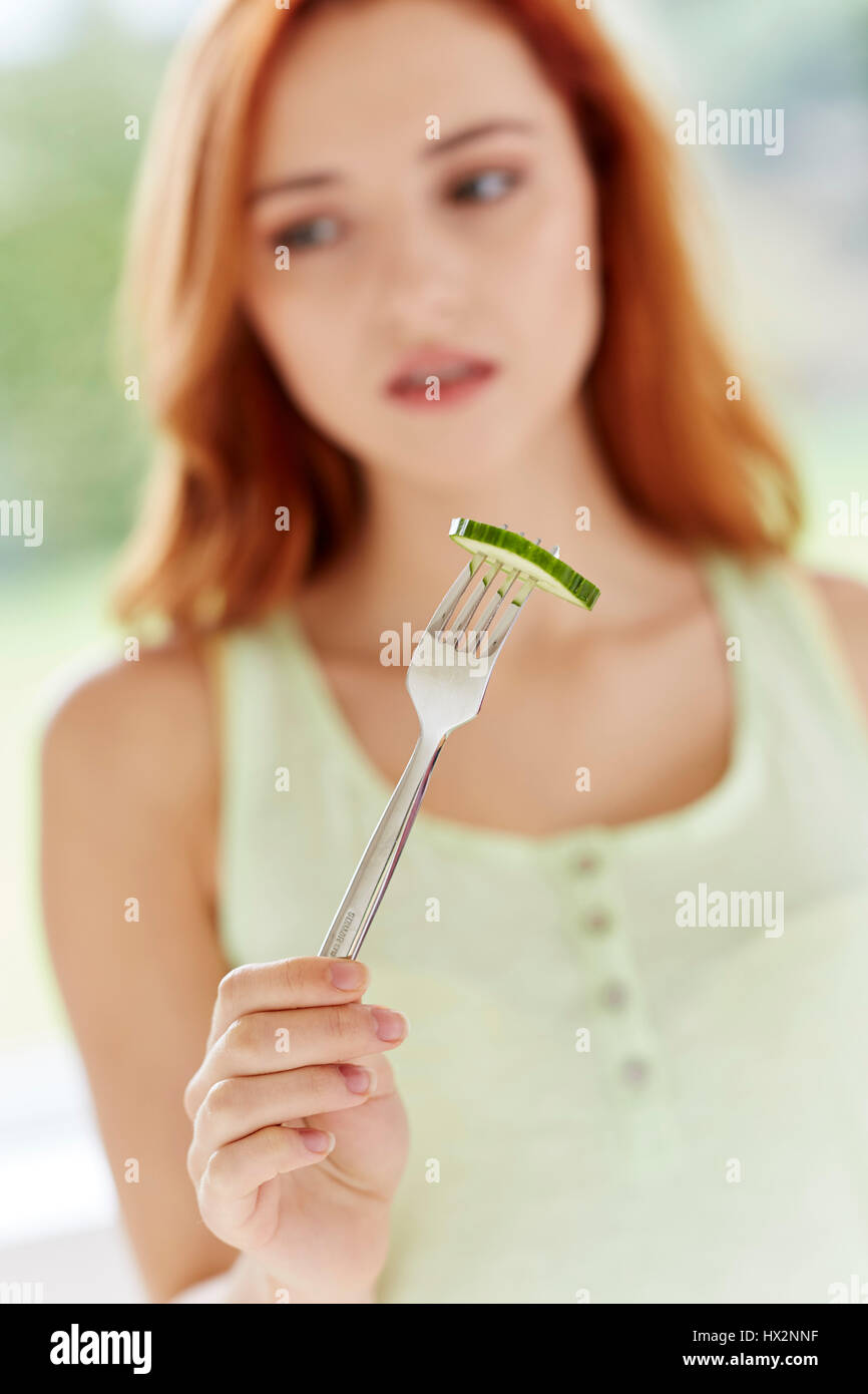 Girl dieting eating slice of cucumber Stock Photo