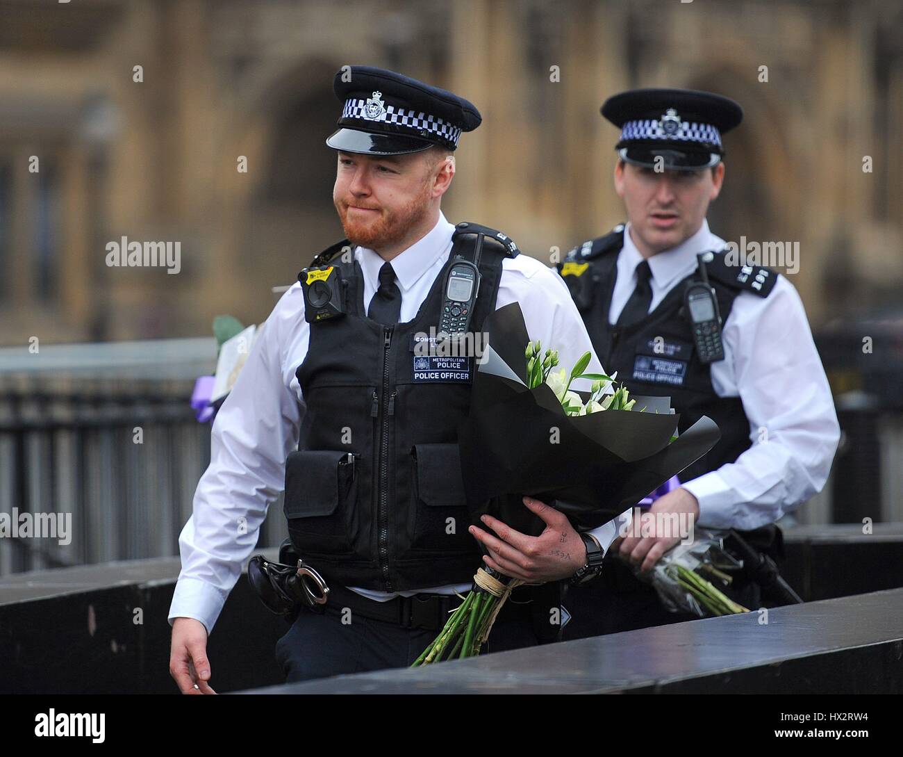 Police officers carrying flowers outside the Houses of Parliament in ...