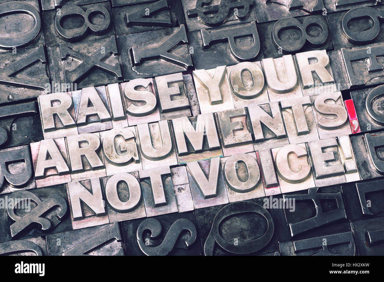 raise your arguments, not voice exclamation made from metallic letterpress blocks with dark letters background Stock Photo