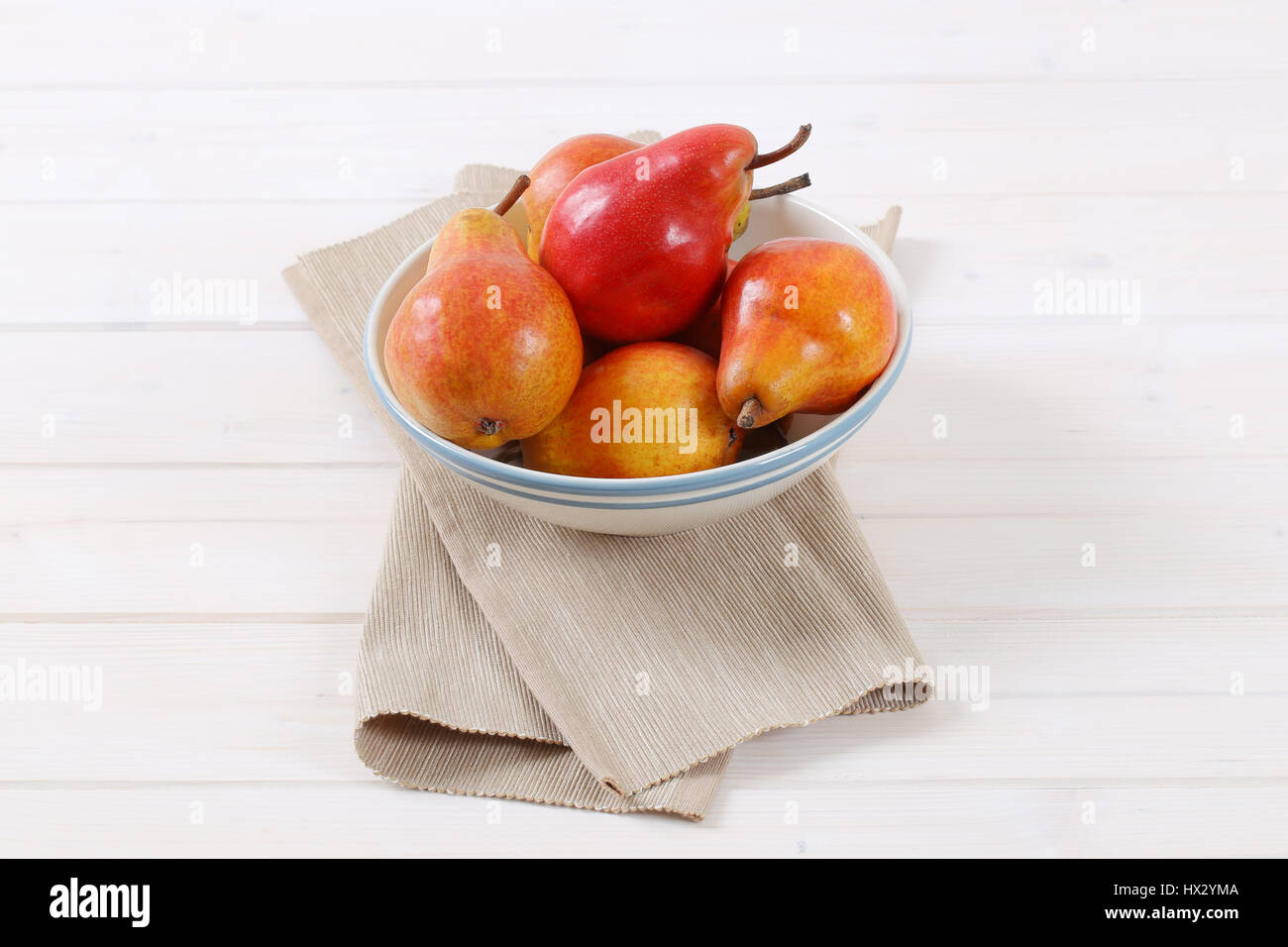 bowl of ripe red pears on white background Stock Photo
