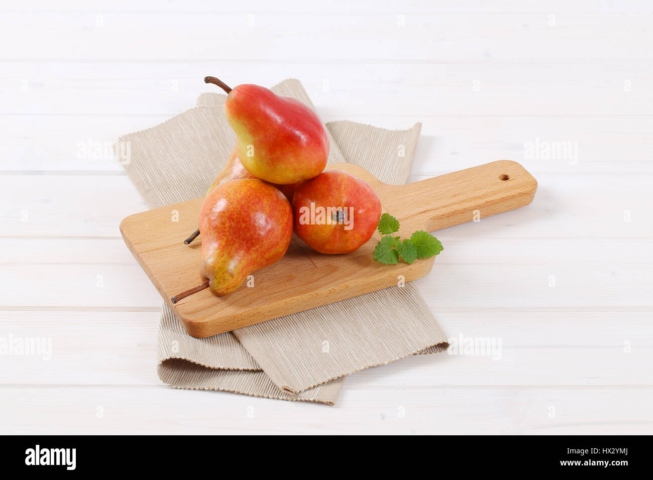 ripe red pears on wooden cutting board Stock Photo