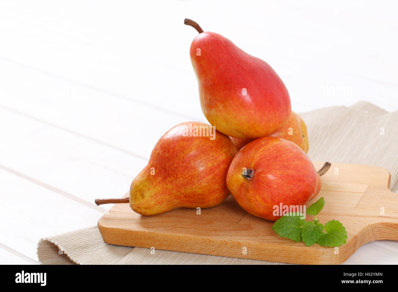 ripe red pears on wooden cutting board - close up Stock Photo
