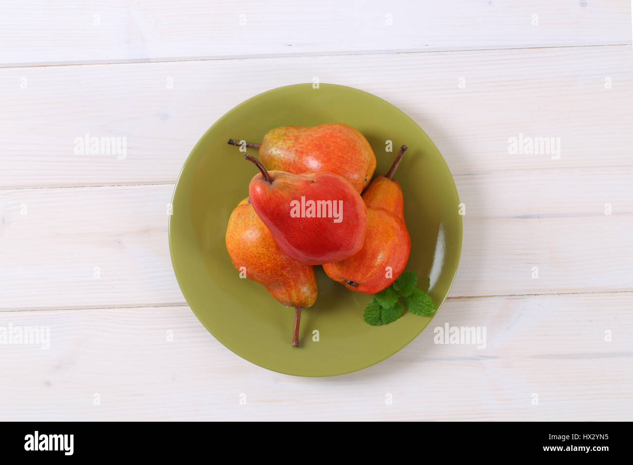 plate of ripe red pears on white background Stock Photo