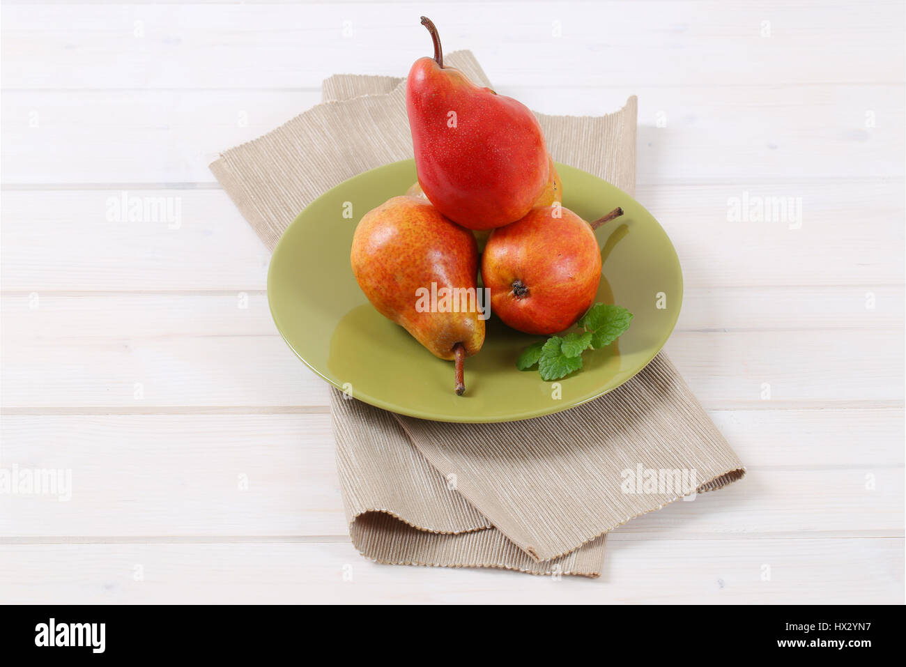 plate of ripe red pears on white background Stock Photo